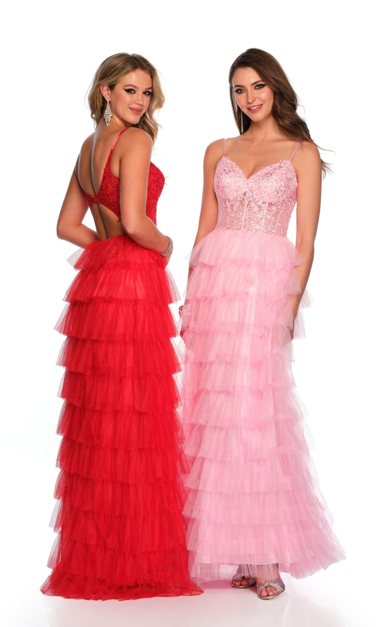 Two women stand side by side in formal wear; one wears a red ruffled evening gown with a low back, and the other models the Dave and Johnny Long Tiered Prom Dress 11148, featuring pink lace, a v-neck, thin straps, and an elegant lace bodice.